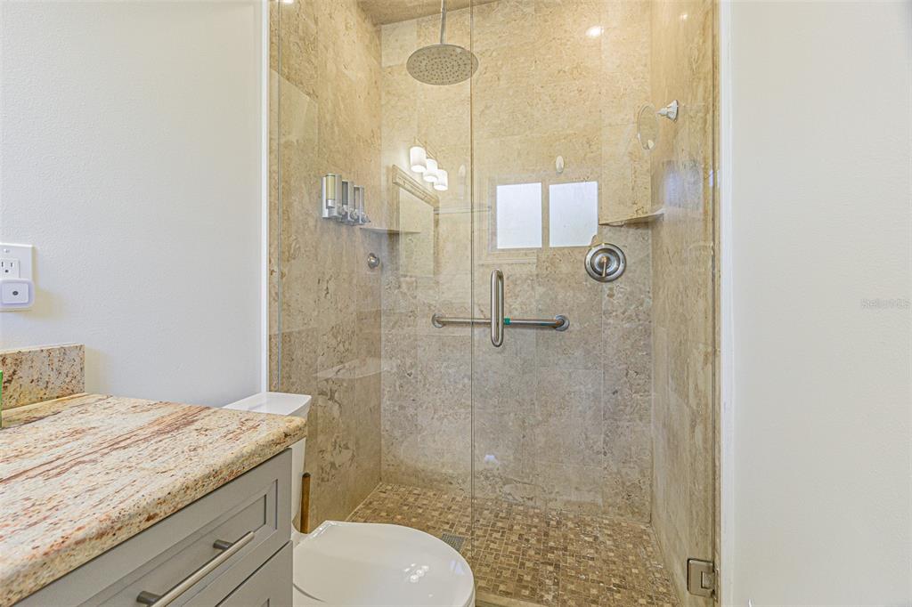 121 Wall Street Redington Shores, FL 33708 - Photo 11 of 38 a bathroom with a granite countertop sink a toilet and shower