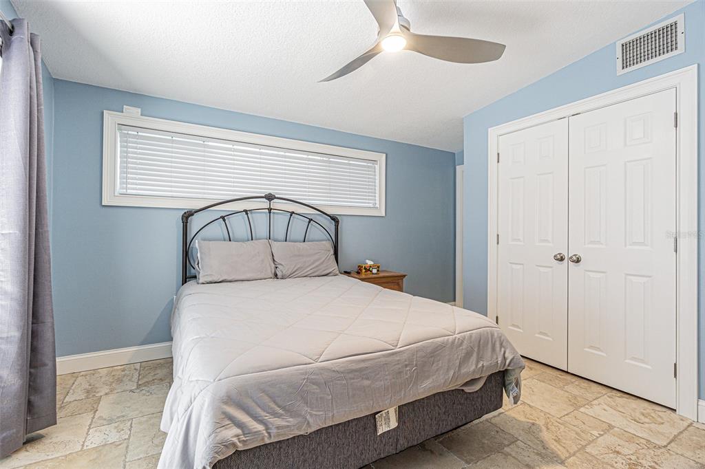 121 Wall Street Redington Shores, FL 33708 - Photo 12 of 38 a bedroom with a bed and a chandelier