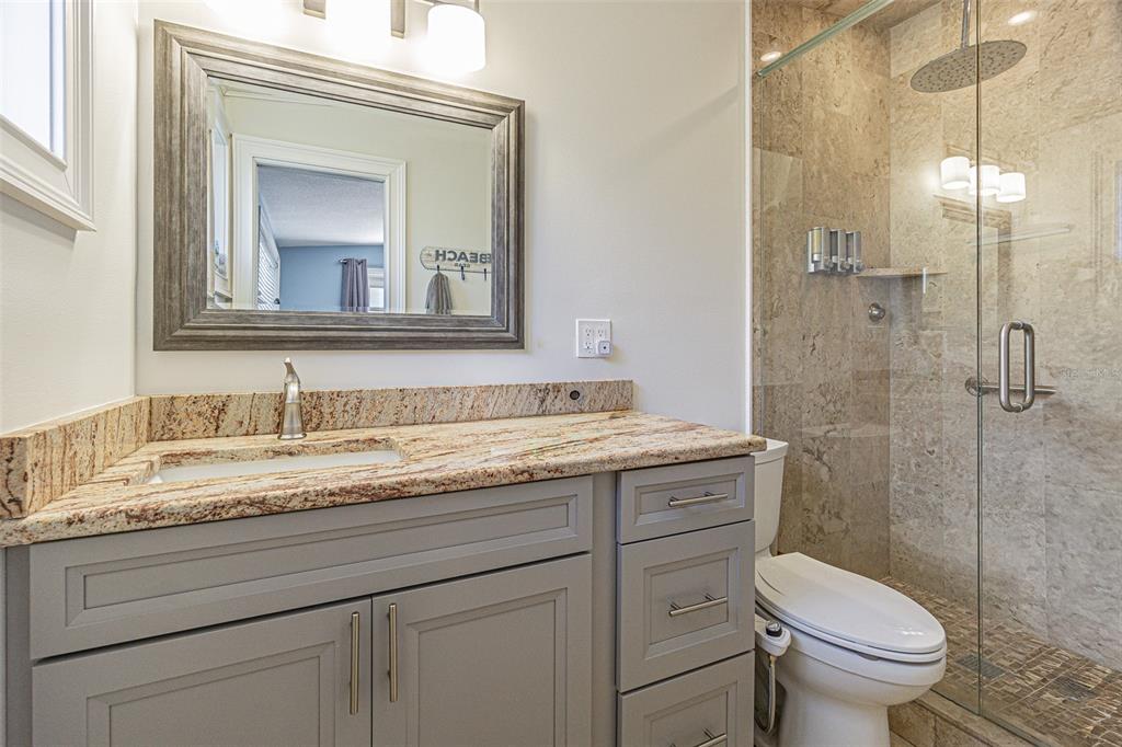 121 Wall Street Redington Shores, FL 33708 - Photo 13 of 38 a bathroom with a granite countertop toilet sink and mirror