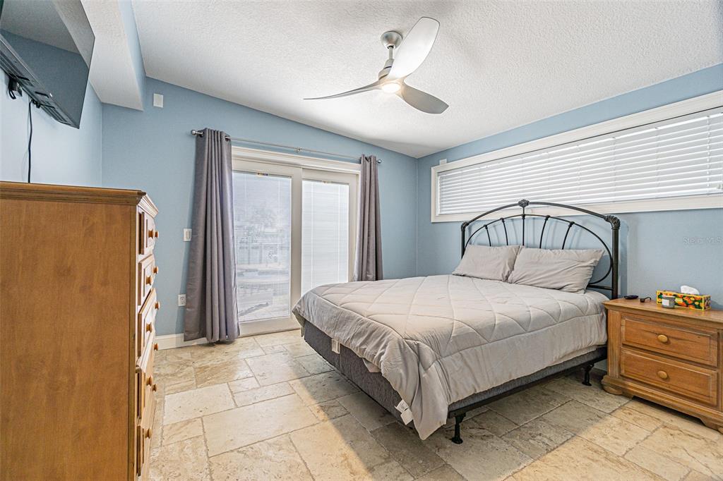 121 Wall Street Redington Shores, FL 33708 - Photo 14 of 38 a bedroom with a bed and a chandelier