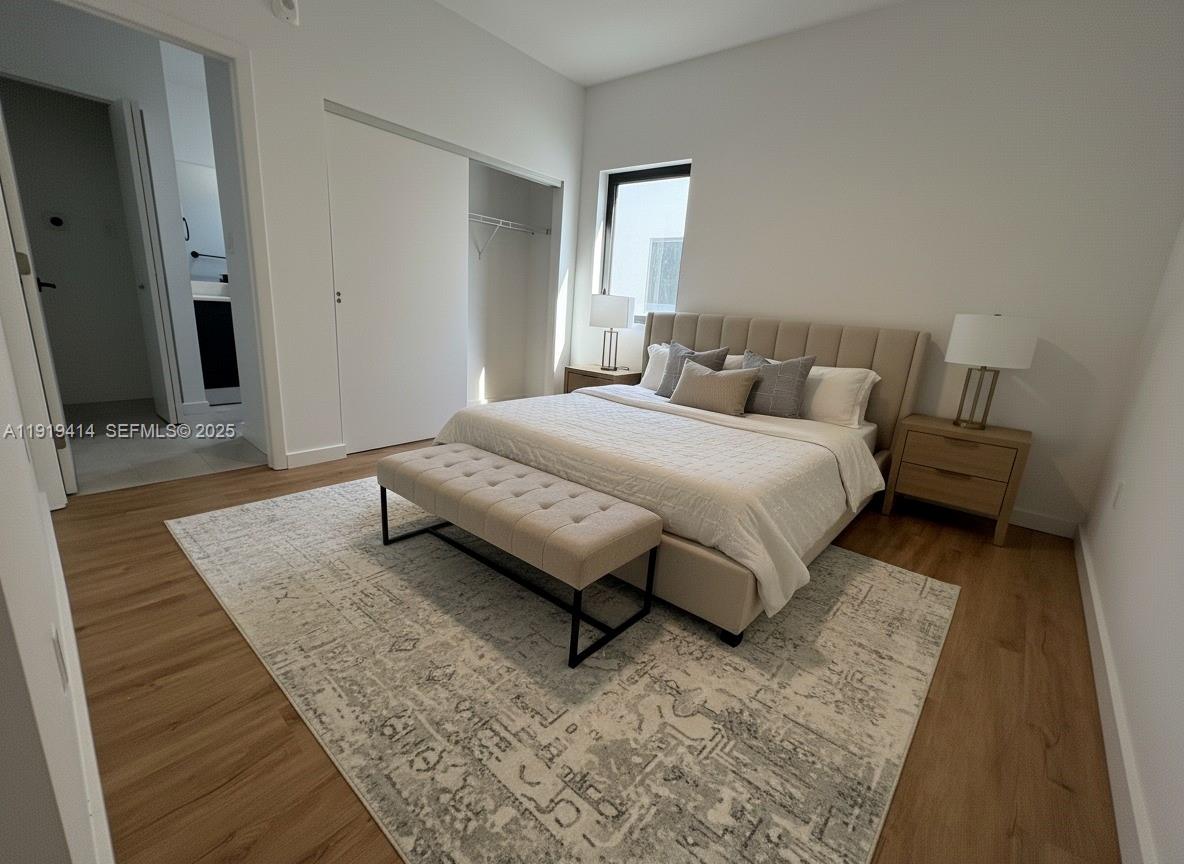 85 Northeast 55th Street, Unit 3 Miami, FL 33137 - Photo 4 of 15 a spacious bedroom with a bed and wooden floor