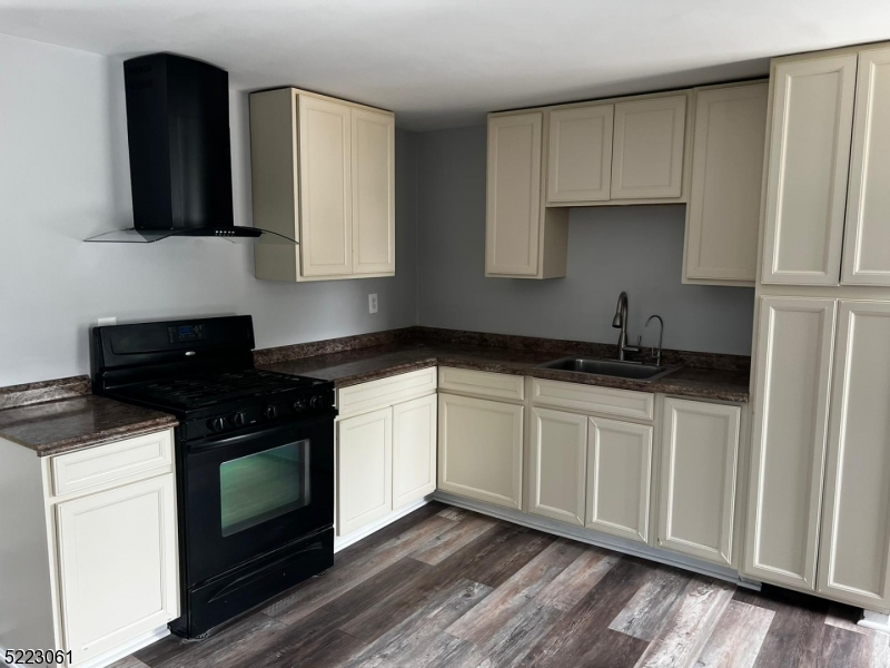 a kitchen with stainless steel appliances granite countertop a stove a sink and white cabinets
