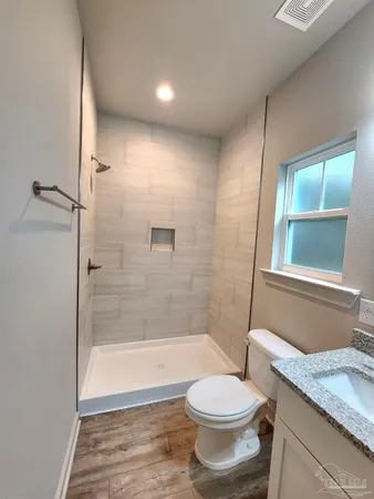 a bathroom with a granite countertop sink toilet and shower