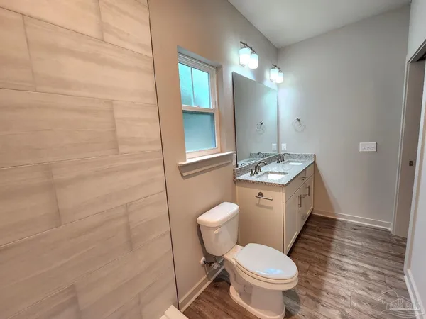 a bathroom with a granite countertop toilet a sink and mirror