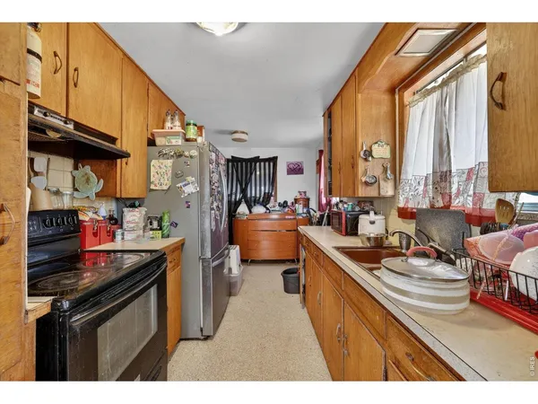 a kitchen with stainless steel appliances granite countertop a sink a stove and a refrigerator