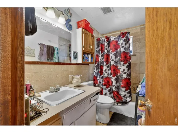 a bathroom with a sink toilet and shower curtain