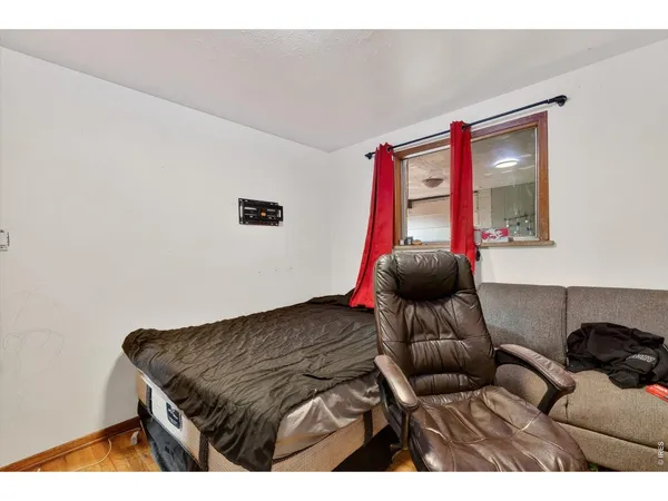 a bedroom with a bed and a large window