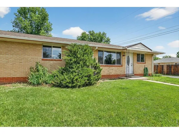 a front view of a house with a yard and potted plants