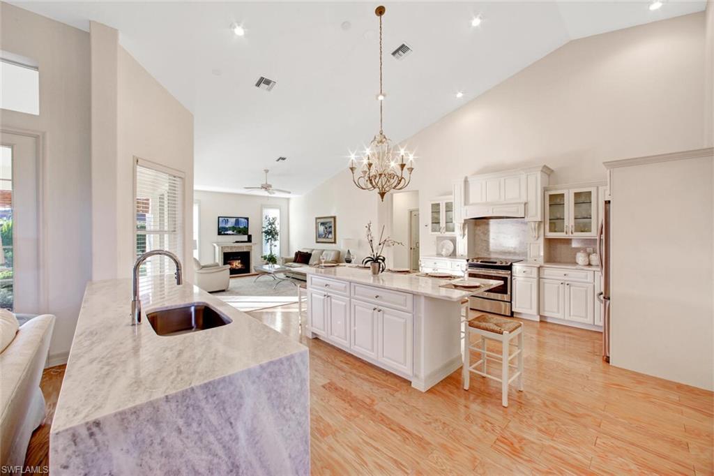 a kitchen with stainless steel appliances kitchen island granite countertop a sink a stove and cabinets
