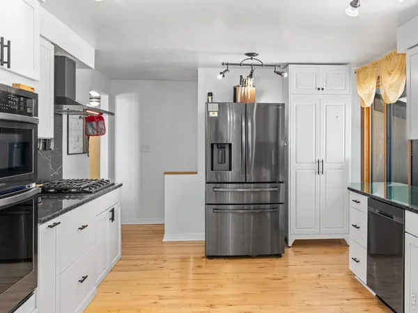 a kitchen with stainless steel appliances granite countertop a refrigerator and a stove top oven