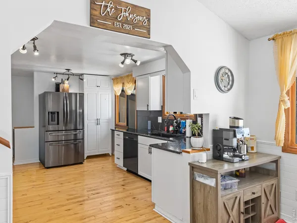 a kitchen with stainless steel appliances granite countertop a refrigerator and a stove top oven
