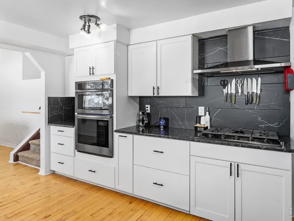 a kitchen with stainless steel appliances a stove a sink and cabinets