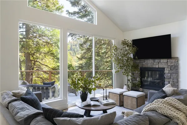 a living room with furniture fireplace and a large window