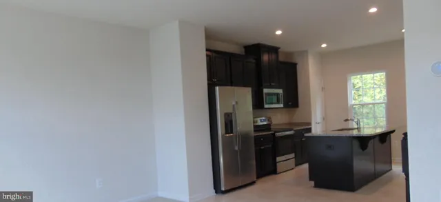 a kitchen with stainless steel appliances a refrigerator and a stove top oven