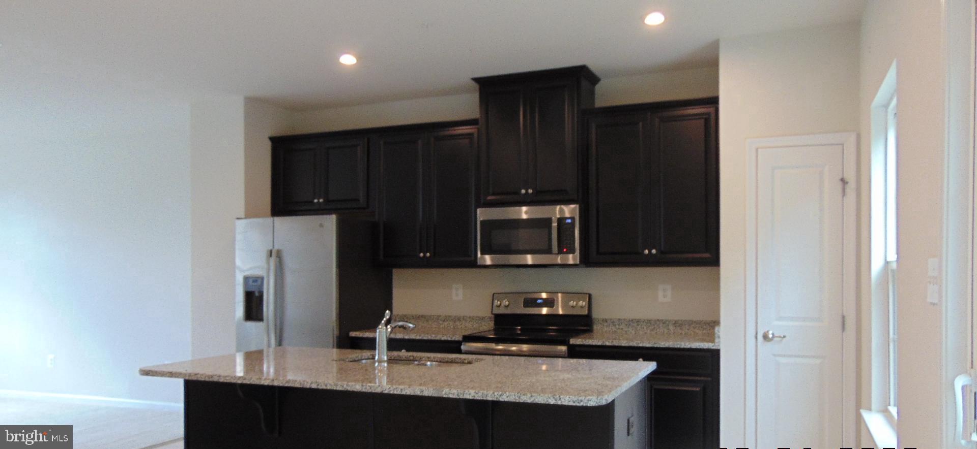 1813 Wind Gate Road Baltimore, MD 21227 - Photo 15 of 44 a kitchen with stainless steel appliances a refrigerator and a stove top oven