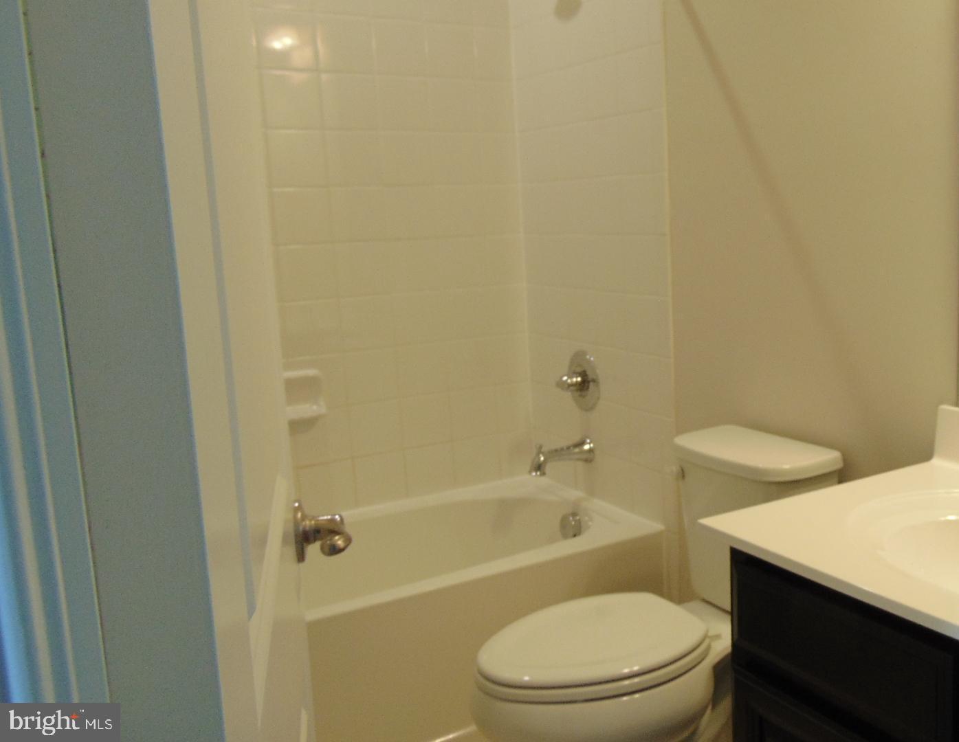 1813 Wind Gate Road Baltimore, MD 21227 - Photo 18 of 40 a white toilet sitting next to a bath tub