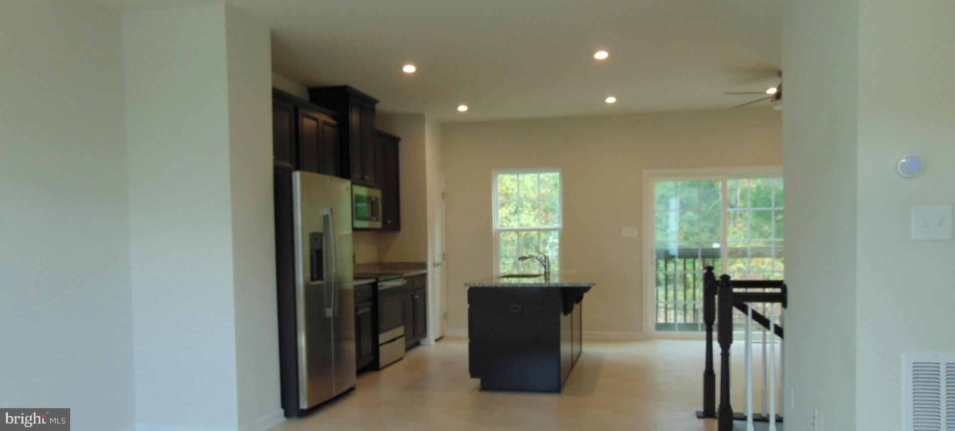 1813 Wind Gate Road Baltimore, MD 21227 - Photo 8 of 40 a kitchen with a refrigerator and a table