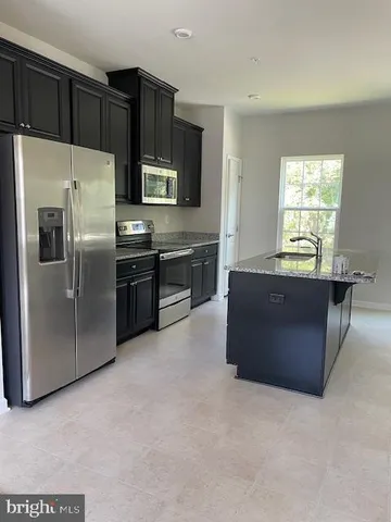 a kitchen with a refrigerator and a stove