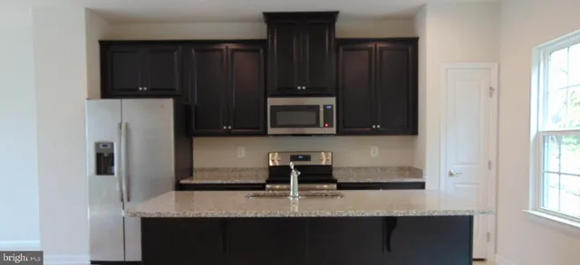 a kitchen with a refrigerator and a table