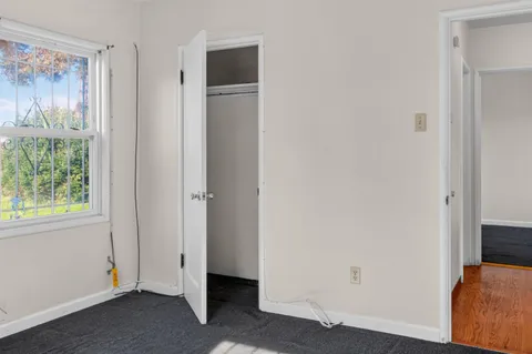 a view of hallway with closet and wooden floor