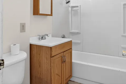 a bathroom with a sink toilet vanity and bathtub