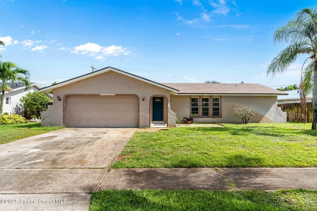 a front view of a house with a yard and potted plants
