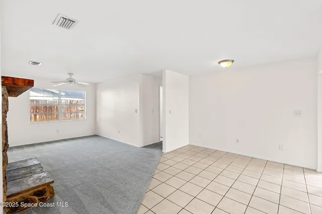 an empty room with windows and fireplace