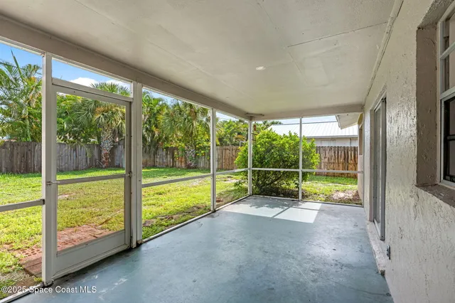 a view of a house with a yard and potted plants