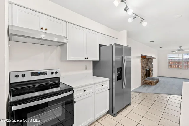 a kitchen with a refrigerator and a stove top oven
