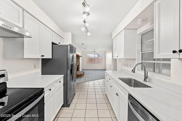 a large kitchen with a sink stainless steel appliances and cabinets