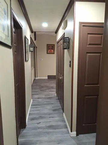 a view of a hallway with wooden floor and staircase