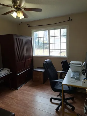 a view of a workspace with furniture and a window