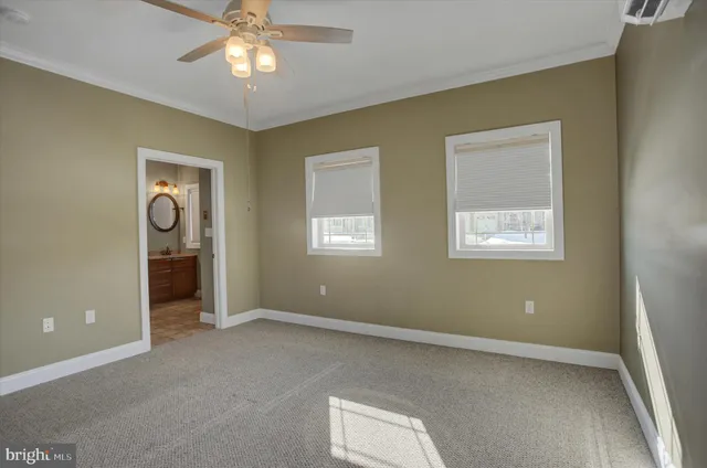 a view of an empty room with window and chandelier fan