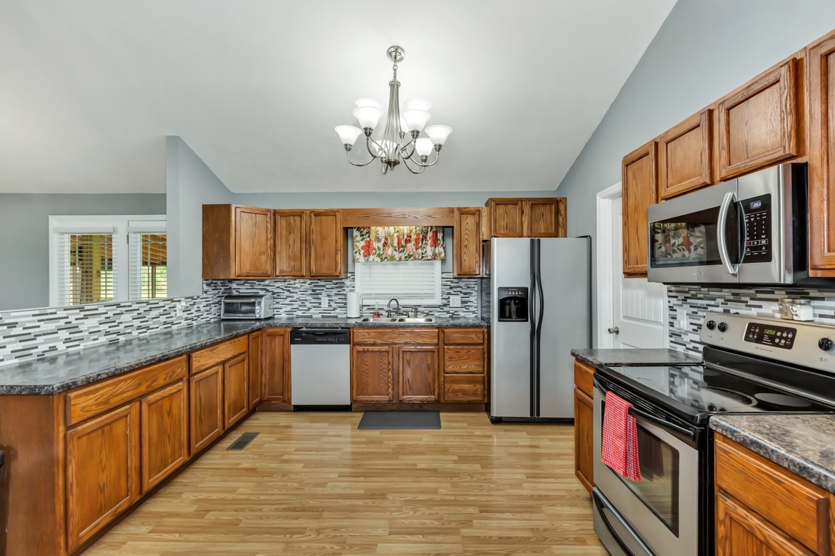 61 Slaughter Pen Road Ardmore, TN 38449 - Photo 8 of 23 a kitchen with stainless steel appliances granite countertop a stove refrigerator sink and microwave