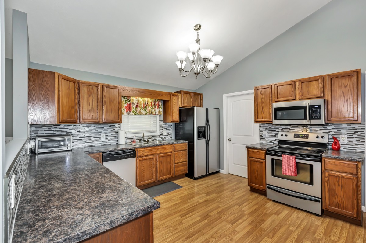 61 Slaughter Pen Road Ardmore, TN 38449 - Photo 9 of 23 a large kitchen with stainless steel appliances granite countertop a stove and a wooden floors