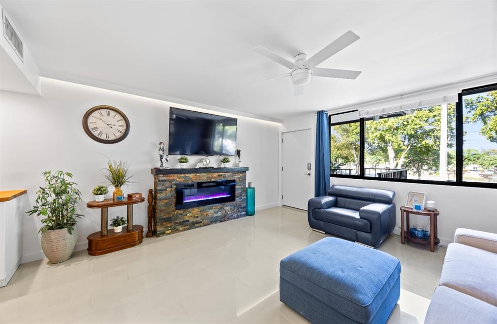 1901 North Andrews Avenue, Unit 222 Wilton Manors, FL 33311 - Photo 5 of 23 a living room with furniture a fireplace and a large window