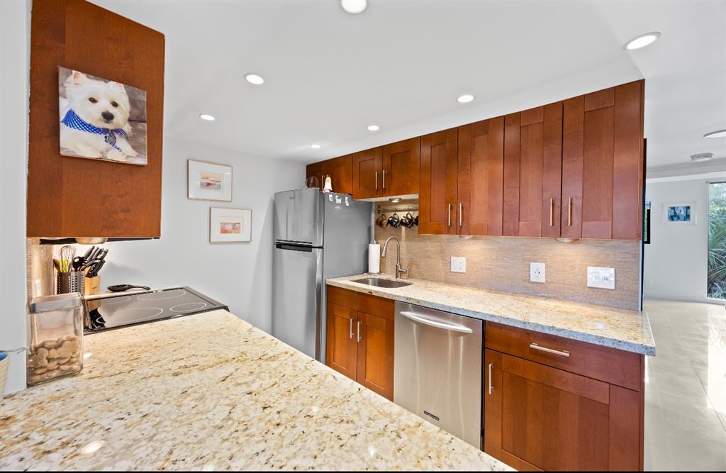 1901 North Andrews Avenue, Unit 222 Wilton Manors, FL 33311 - Photo 8 of 23 a kitchen with stainless steel appliances granite countertop a sink stove and refrigerator