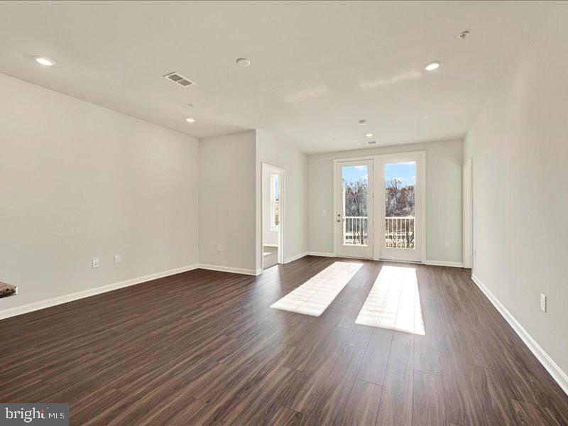 4003 Seaside Alder Road, Unit 308 ROSE Bowie, MD 20720 - Photo 16 of 44 an empty room with wooden floor and windows