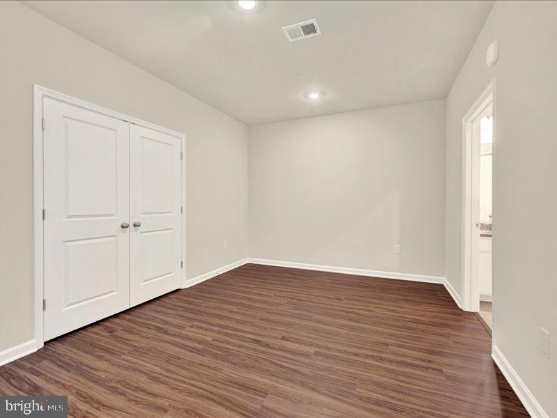 4003 Seaside Alder Road, Unit 308 ROSE Bowie, MD 20720 - Photo 4 of 44 a view of an empty room with wooden floor