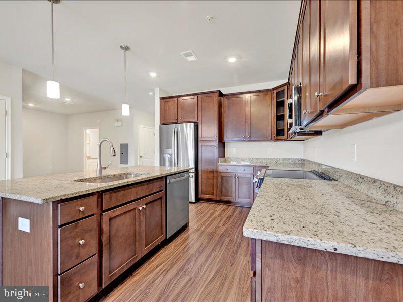 4003 Seaside Alder Road, Unit 308 ROSE Bowie, MD 20720 - Photo 8 of 44 a kitchen with stainless steel appliances granite countertop a sink a stove and a wooden floors