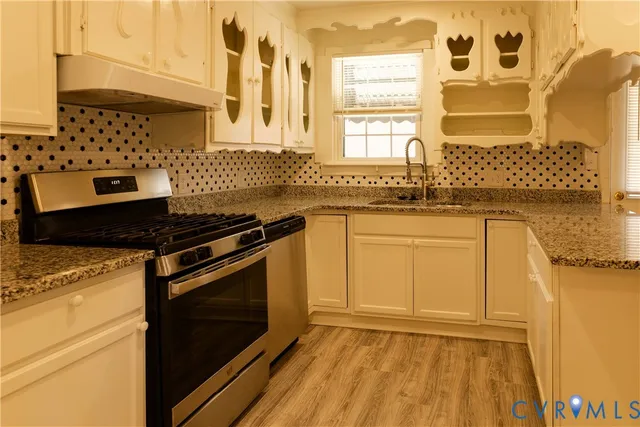 a kitchen with granite countertop cabinets stainless steel appliances and a sink
