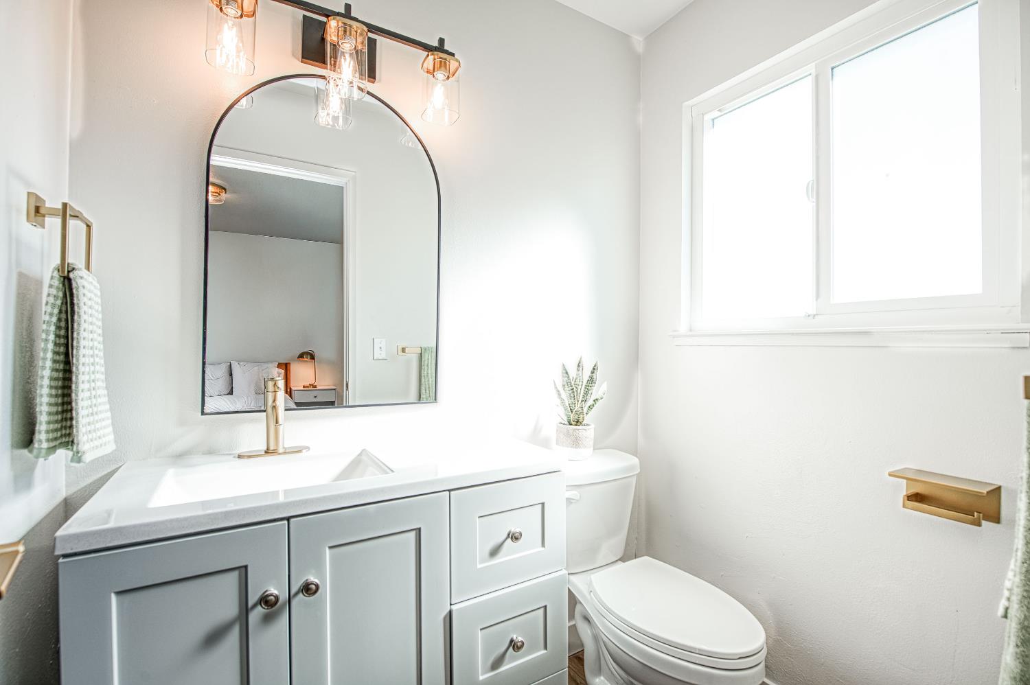 1747 Gettysburg Avenue Clovis, CA 93611 - Photo 27 of 39 a bathroom with a sink a toilet and mirror