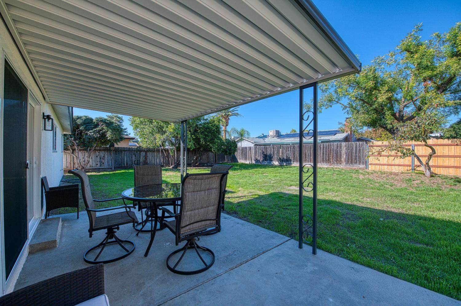 1747 Gettysburg Avenue Clovis, CA 93611 - Photo 29 of 39 a view of a backyard with table and chairs under a large umbrella