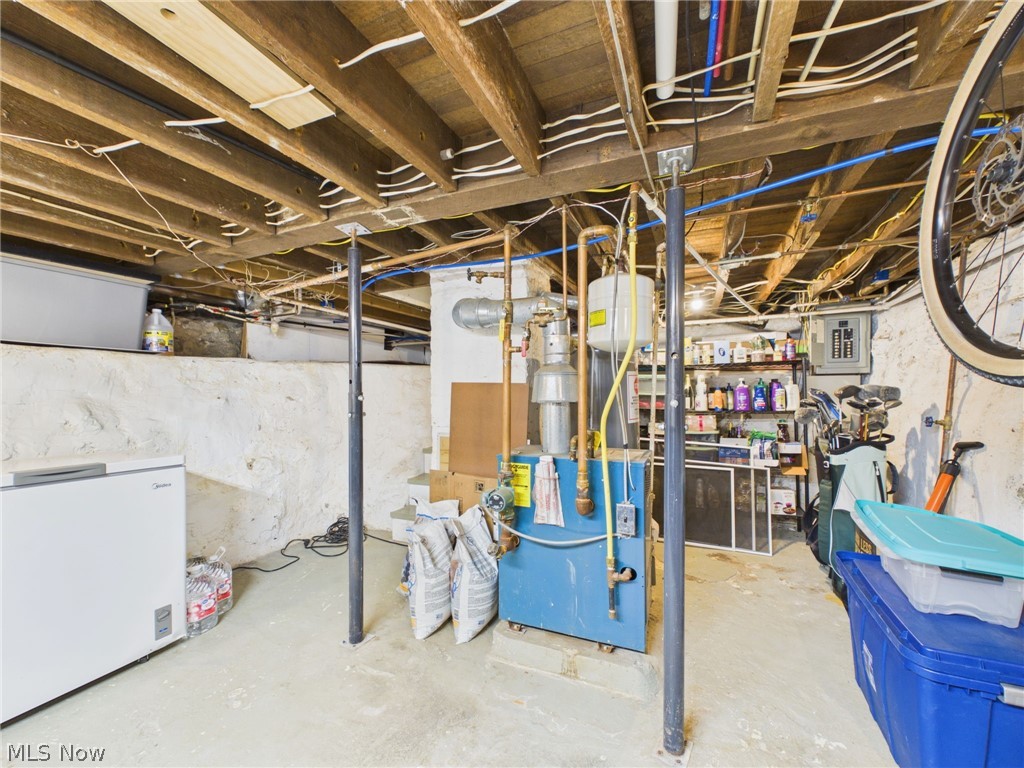 3490 County Line Road Madison, OH 44057 - Photo 38 of 42 Utility space featuring exposed ceiling joists, concrete flooring, and a visible water heater system