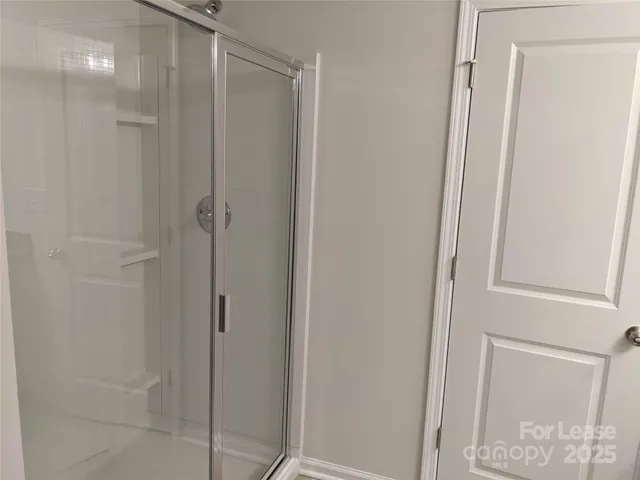 a bathroom with a shower and a glass door