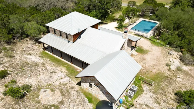 an aerial view of a house with swimming pool and sitting space