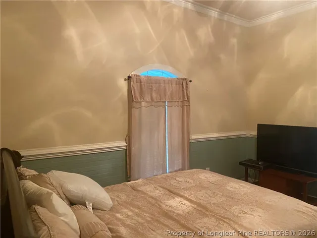 a bedroom with a bed and a chandelier