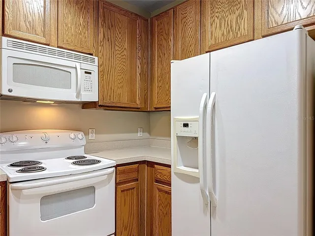 a kitchen with stainless steel appliances white cabinets and a refrigerator