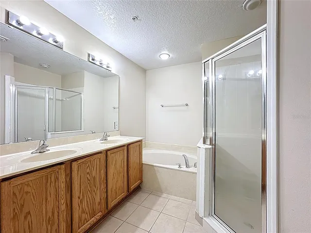 a bathroom with a double vanity sink mirror and bathtub