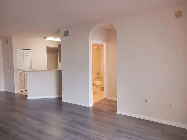 a view of a kitchen with wooden floor and a refrigerator